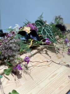 Kestävän kehityksen mukainen arkunkoriste. Asettelupohjana on rahkasammalta ja keppejä. Sidosmateriaalina on paperilankaa ja hamppunarua.